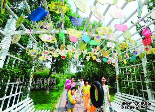 平水橋公園綠化廊架上懸掛的社會(huì)主義核心價(jià)值觀小吊牌吸引了過往游客的目光
